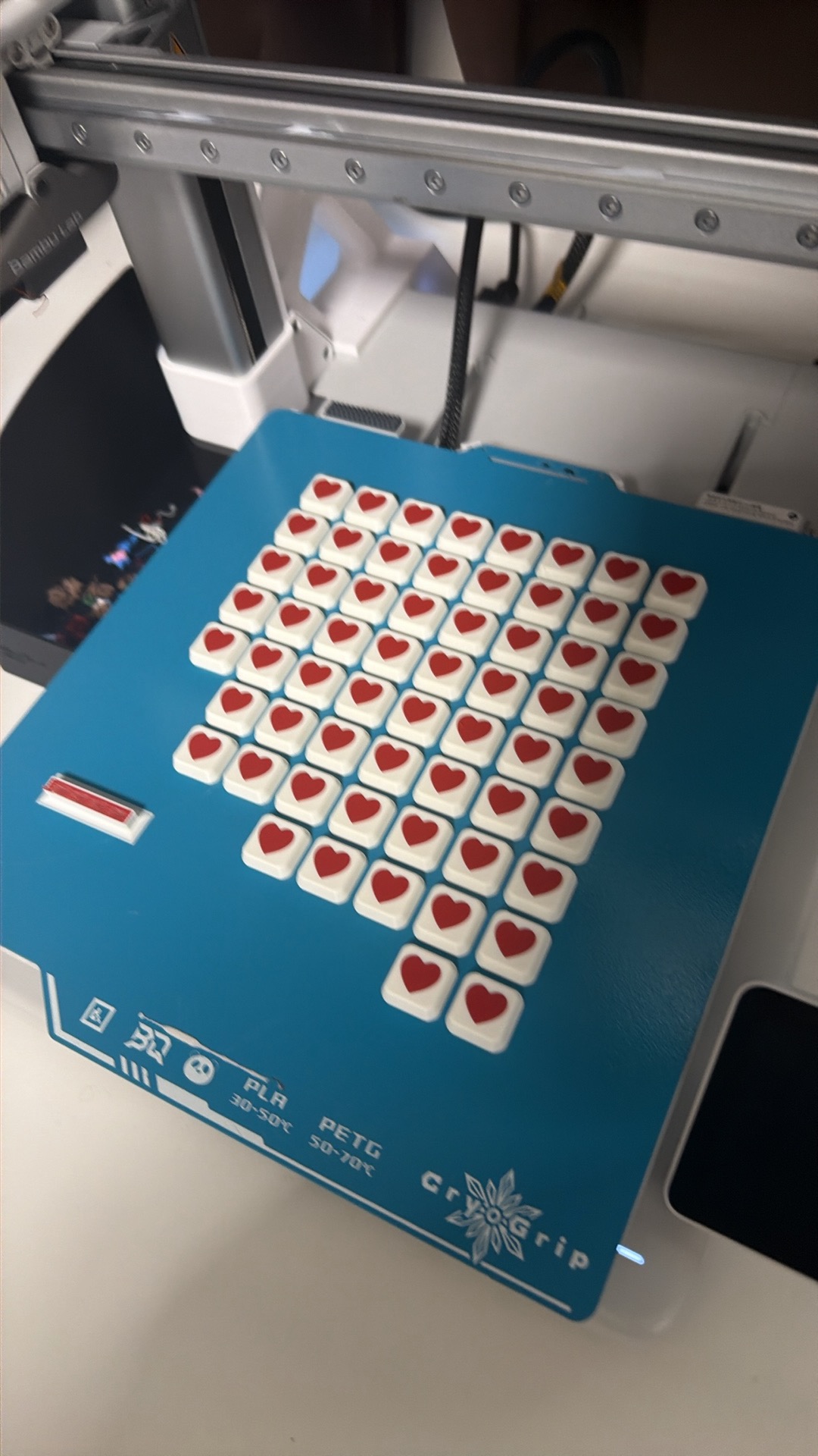 A batch of red and white heart clickers on a blue print bed